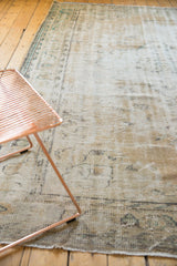 Distressed Turkish Oushak carpet texture, even wear across foundation, muted ivory and sea-foam green motifs.