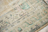 Distressed vintage Oushak carpet pile showing worn knot heads, ivory, and sea-foam green.