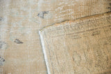 Distressed Oushak rug close-up showing worn pile, visible knot heads, and hand-knotted woven back.