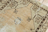 Detail of distressed Oushak rug with exposed foundation and dark geometric patterns.