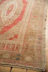 Distressed texture, faded red, and bronze geometric patterns on vintage Oushak rug corner.
