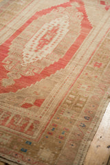 Distressed Oushak rug corner detail with pale red and faded bronze spandrel.