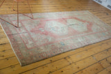 Distressed Oushak runner with muted blush, beige, and blue geometric border, featuring fringed end.
