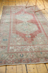 Distressed Oushak runner, close-up of secured side edge with low pile and muted patterns.