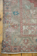 Distressed Oushak runner corner with geometric motifs in blush, beige, seafoam, and fringe.