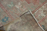 Hand-knotted reverse and distressed pile of vintage Oushak rug with muted blush, beige, and blue.