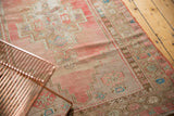 Abrashed vintage Oushak runner section with faded pink, beige, and blue geometric motifs.