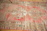 Distressed vintage Oushak runner's geometric border with faded pink and beige tones.
