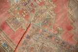 Distressed Oushak rug corner: blush geometric pattern, worn knot heads, and hand-knotted reverse.
