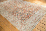 Worn terra cotta, aqua floral motifs on a distressed Sivas carpet corner.