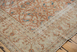 Distressed Sivas rug corner, intricate beige, terra cotta, and aqua floral border.