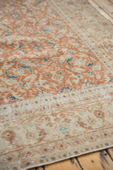 Terra cotta floral patterns and aqua accents on worn, distressed Sivas rug pile.