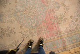 Distressed Oushak rug with ivory, pink, and powder blue vinery, showing even wear.