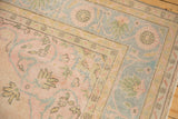 Decorative distressed Oushak rug corner, revealing pastel pink, blue, and ivory pile wear.