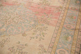 Distressed Oushak rug with scalloped medallion, faded pink, powder blue, ivory tones.