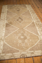 Distressed Oushak runner's intricate geometric patterns in oxidized silver and dusty bronze tones.