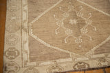 Low-pile distressed Oushak rug corner, featuring intricate geometric drawing and step border.