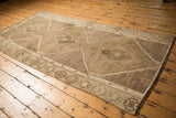 Stepped geometric border and low pile texture of a vintage distressed Oushak rug runner.
