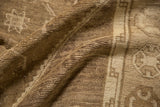 Distressed Oushak rug, low pile with geometric motifs and time-softened brown tones.