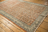 Distressed pale rust orange field with vinery and worn ivory meandering border of Oushak rug.