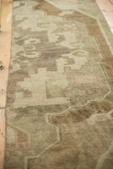 Vintage Oushak runner's low pile, revealing scrolling rectilinear patterns in coffee brown, ivory, and blush.