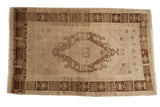 Decorative distressed Oushak rug, concentric medallion and germinating seed border in bronze and ivory.