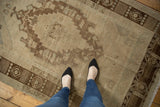 Distressed Oushak rug texture, with mostly even wear, faint foundation, ivory and bronze tones.