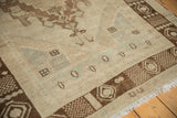 Distressed ivory pile texture, dark bronze geometric border, and fringed corner.