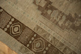 Chocolate bronze geometric border of a distressed Oushak rug, with worn pile and visible foundation.