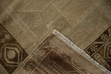 Distressed vintage Oushak rug corner showing worn pile, ivory fringe, and geometric dark bronze border.