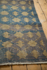 Fringed end of the distressed Sparta runner, revealing visible foundation and aqua, grey, gold tones.
