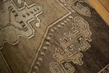 Geometric scrolling vinery on the hand-knotted Oushak rug, showing even pile wear.