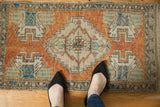 Distressed Oushak rug mat with a stepped medallion, pale rust, ivory, and mint green hues.