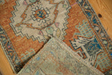 Distressed Turkish Oushak rug showing its low pile, fringe, and hand-knotted reverse.