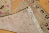 Hand-knotted foundation, distressed pile, and ivory fringe of a vintage Oushak rug.