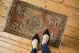 Distressed Oushak rug mat featuring worn pile and faded copper, beige, bronze colors.