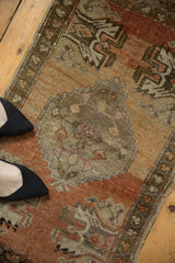 Vintage distressed Oushak rug's stepped medallion and floral motifs with aged copper texture.