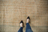 Distressed Oushak rug texture, showing subtle vinery, faded orange, and pale green motifs.