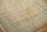 Close-up of distressed Oushak carpet with even wear, faded pale orange and seafoam vinery.