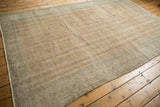 Distressed vintage Oushak carpet texture with faded pale orange and seafoam green border.