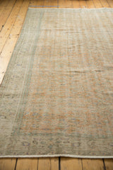 Fringe and worn pile detail of a distressed Oushak rug, showing faded orange and muted green tones.