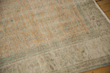 Vintage distressed Oushak carpet pile with faded pale orange, seafoam green, and beige.