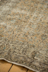 Distressed Oushak pile with muted beige, aqua, and brown tones, showing foundation wear.