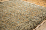 Textured distressed Oushak rug, with aqua blue floral motifs and visible foundation.