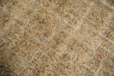 Textured vintage Oushak rug pile displaying distressed beige, aqua, brown floral vinery.