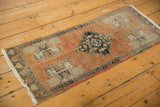 Stepped medallion and floral motifs on the distressed Oushak rug's rust field.