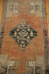 Distressed Oushak runner's stepped charcoal medallion with floral design and terra cotta field.