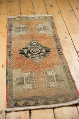 Vintage distressed Oushak rug's corner with low pile, fringe, and red selvage.