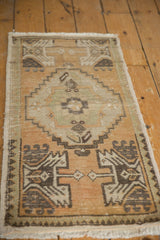 Distressed vintage Oushak rug corner showing geometric patterns, worn pile, and fringe.