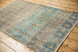 Distressed Sparta rug, highlighting lattice floral pattern and bold abrashes of aqua blue and grey.